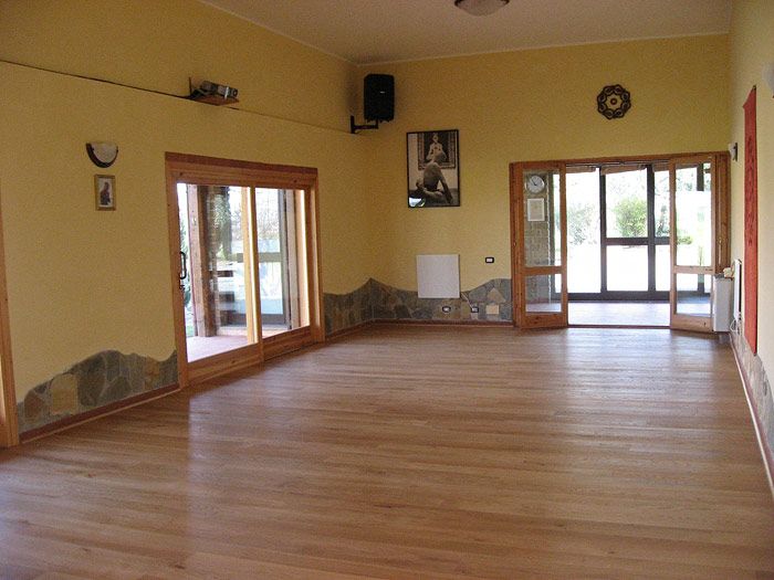 The practice room at the Casale, a wooden floor and doors opening onto the garden.