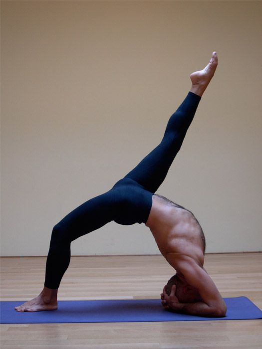 Lino Miele in a headstand with the legs opened wide.